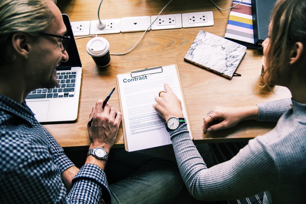 Two people checking a rental contract clause by clause before signing